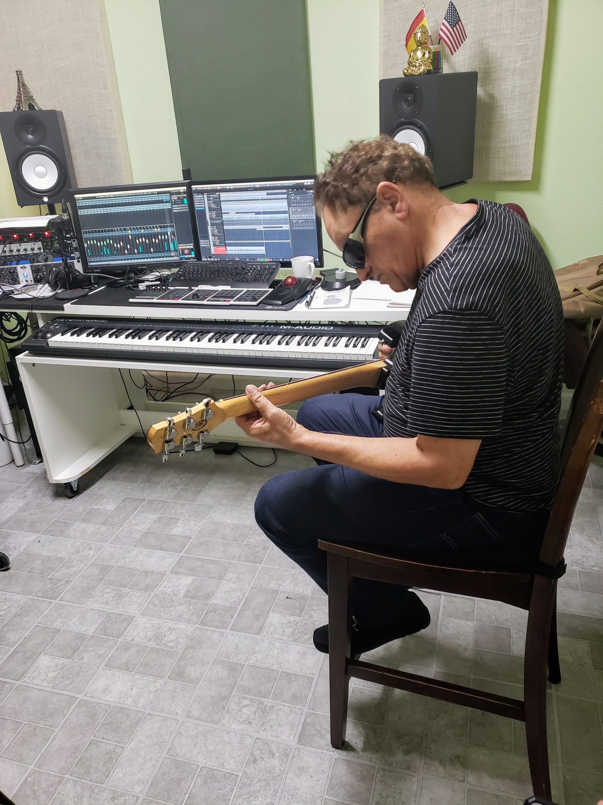 Músico grabando guitarra en la sala de control del estudio